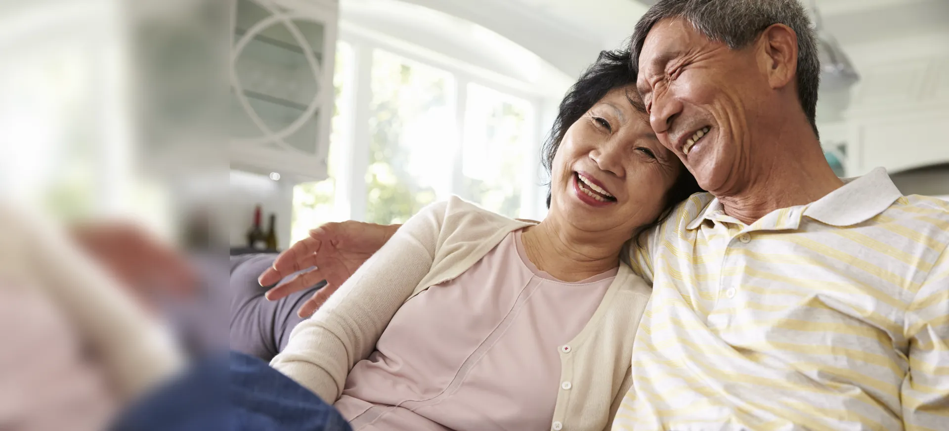 Hai vợ chồng lớn tuổi tựa vào nhau cười tươi